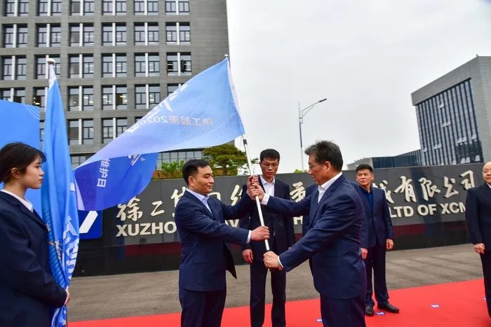 sb起重机械事业部副总经理史先信向sb重型服务备件中心总经理姜凡科、sb履带客户服务中心总经理郝敏、sb塔机营销公司副总经理吴建明以及供应商、经销商代表授旗